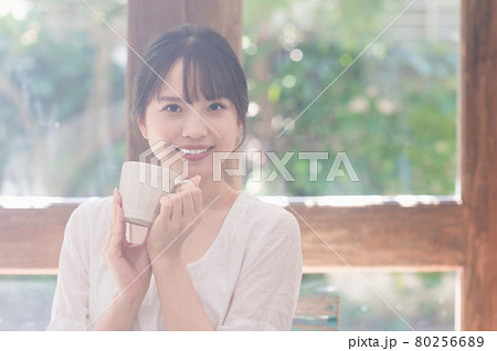 リビングでコーヒーを飲む若い女性 80256689
