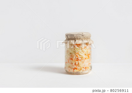 Homemade sauerkraut. Fermented food. Sauerkraut with carrots in a glass jar on a white wooden background Homemade sauerkraut. Fermented food. Sauerkraut with carrots in a glass jar on a white wooden background 80256911