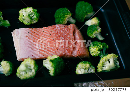 Fresh organic atlantic salmon fillet on baking tray with green broccoli florets as healthy food nutrition and keto diet 80257773