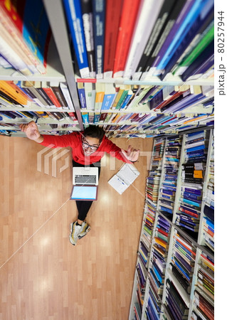 the students uses a notebook, laptop and a school library 80257944