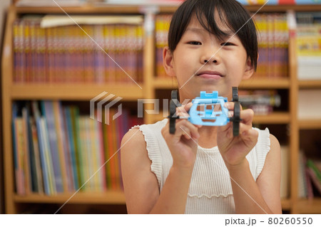 夏休みの家で工作の車模型を作っている小学生の女の子の様子 80260550
