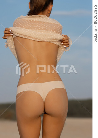 Sexy woman taking off top on beach - Stock Photo [79816064] - PIXTA