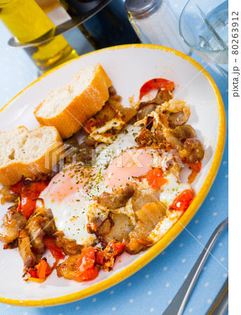 Eggs fried with pork meat and tomatoes 80263912