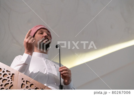 Muslims young arabic Imam has a speech on friday afternoon prayer in mosque. 80267006