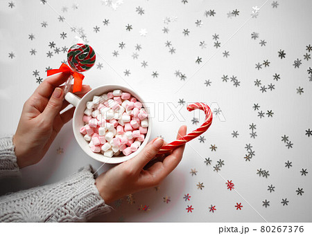 beautiful female hands hold a cup of cocoa with marshmallows. view from above beautiful female hands hold a cup of cocoa with marshmallows. view from above 80267376