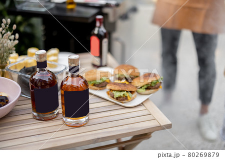 Alcohol drinks on a table during a picnic with grill Alcohol drinks on a table during a picnic with grill 80269879