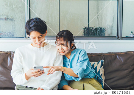 一緒にスマホを見る若い夫婦（カップル） 80271632