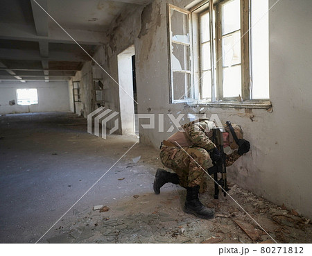 soldier in action near window changing magazine and take cover 80271812