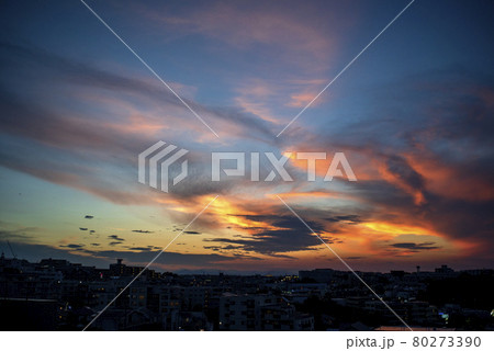 西の空に日は沈み落日は雲を赤く照らす 80273390