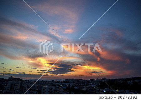 西の空に日は沈み落日は雲を赤く照らす 80273392