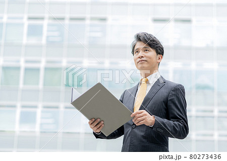 オフィス街に立つミドルエイジのビジネスマンのポートレート オフィス街に立つミドルエイジのビジネスマンのポートレート 80273436
