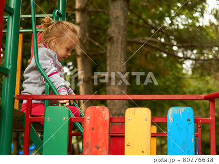 The little cute toddler child goes on the steps of the playground in the park 80276638
