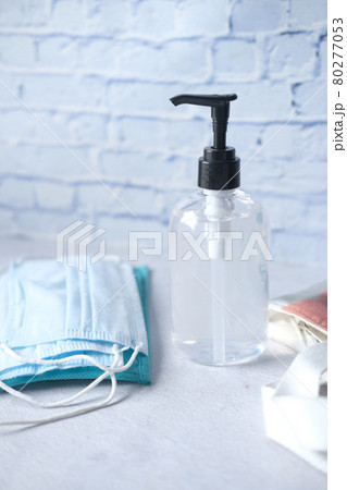 Surgical masks, thermometer and hand sanitizer on orange background  80277053
