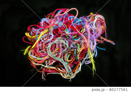 Ball of multicolored tangled threads for needlework on black background 80277561