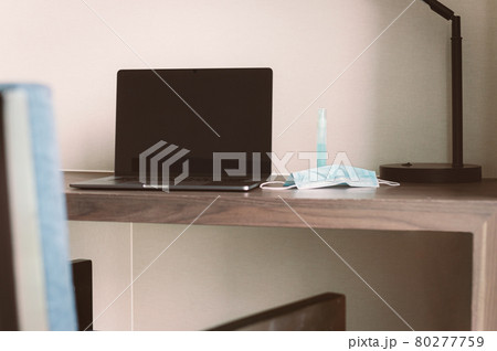 New normal laptop computer and medical mask on table in hotel room. 80277759