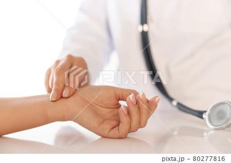 Close-up hands of doctor, therapeutic or medical advisor measuring pulse to patient, sick. Concept of healthcare, care and medicine. Close-up hands of doctor, therapeutic or medical advisor measuring pulse to patient, sick. Concept of healthcare, care and medicine. 80277816