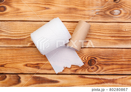 Torn toilet paper roll on a wooden background Torn toilet paper roll on a wooden background 80280867