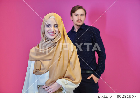 Portrait of happy young muslim couple standing isolated on pink background Portrait of happy young muslim couple standing isolated on pink background 80281907