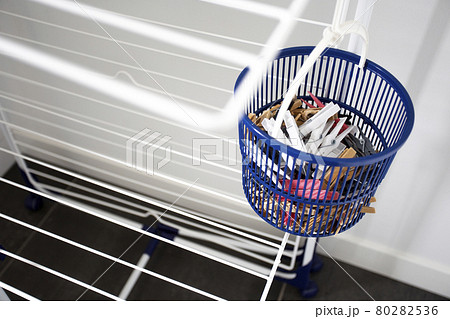 Empty laundry drying rack with clothespins in blue basket, clothing rack dryer clean new design indoors Empty laundry drying rack with clothespins in blue basket, clothing rack dryer clean new design indoors 80282536