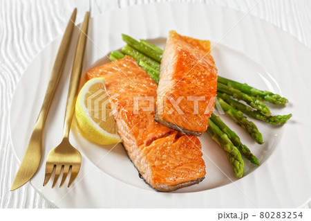 roast salmon fillets with lemon and asparagus roast salmon fillets with lemon and asparagus 80283254