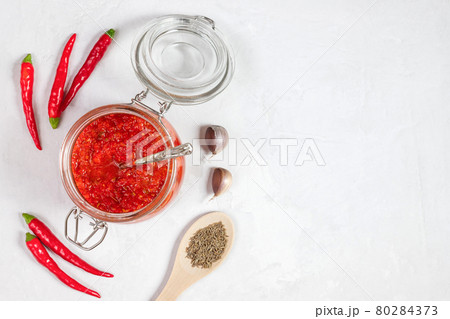 Hot chili pepper sauce paste harissa. Adjika. Traditional Tunisia, Georgian and Arabic cuisine. Homemade rose harissa in a glass jar. 80284373