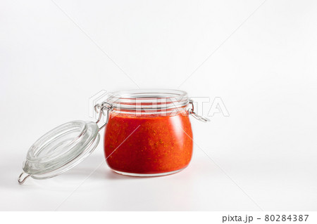 Hot chili pepper sauce paste harissa. Adjika. Traditional Tunisia, Georgian and Arabic cuisine. Homemade rose harissa in a glass jar. 80284387