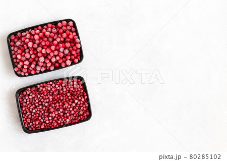 Frozen berries in containers on a white background. Cowberries and cranberries. Frozen food. Copy space, view from above. Frozen berries in containers on a white background. Cowberries and cranberries. Frozen food. Copy space, view from above. 80285102