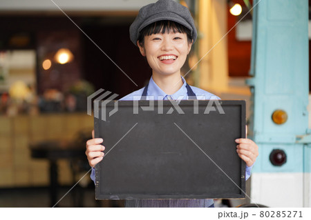キッチンカーの前でメッセージボードを持つ女性店員 キッチンカーの前でメッセージボードを持つ女性店員 80285271