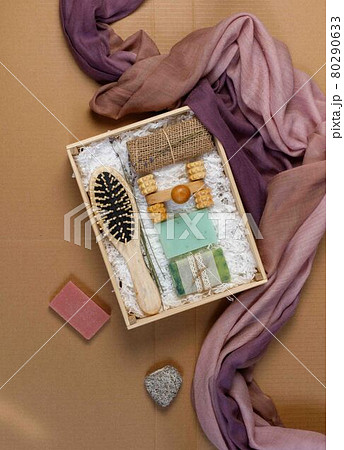 A gift set of eco-friendly products for skin and hair care. Dry shampoo, natural washcloth, wooden comb. On a craft background, with space, vertical 80290633