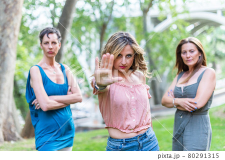 A mature adult woman making the stop gesture with a serious expression 80291315