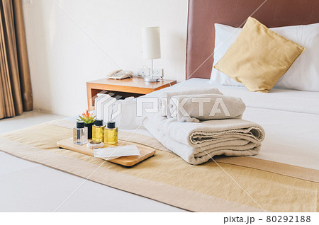Group set of free hotel amenities (such as towels, shampoo, soap, gel etc) on the bed. Hotel amenities is something of a premium nature provided in addition to the room when renting a room. 80292188
