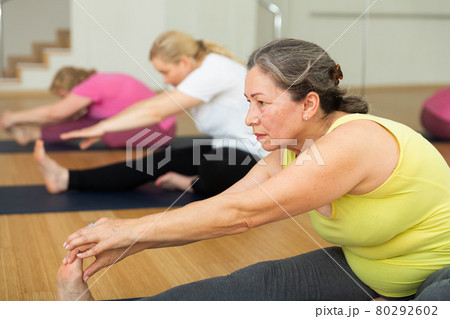 Women are doing head-to-knee pose Women are doing head-to-knee pose 80292602