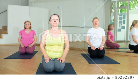 Group of people exercising during yoga class 80292897