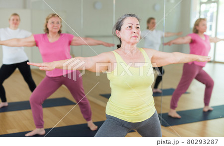 Active senior woman practicing yoga at group Active senior woman practicing yoga at group 80293287