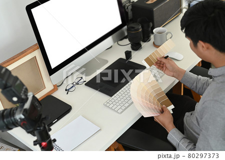 Cropped shot of graphic designer or photographer is working on color selection, colour swatches at work space. Cropped shot of graphic designer or photographer is working on color selection, colour swatches at work space. 80297373