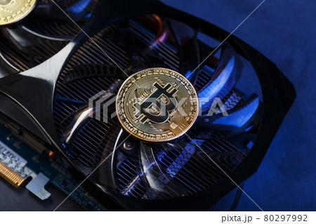 Video card with a gold coin Bitcoin on the cooler close-up. Video card with a gold coin Bitcoin on the cooler close-up. 80297992