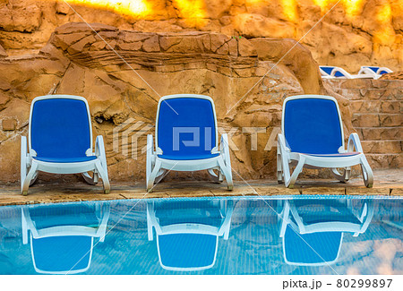 Several of sun loungers by a beautiful swimming pool Several of sun loungers by a beautiful swimming pool 80299897