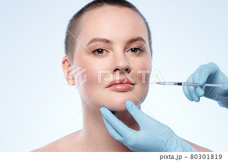 Beautiful woman with short hair gets a beauty injection in her face Beautiful woman with short hair gets a beauty injection in her face 80301819