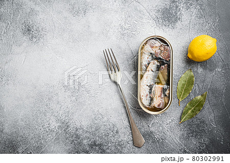 Canned sardine in oil, on gray stone table background, top view flat lay, with copy space for text Canned sardine in oil, on gray stone table background, top view flat lay, with copy space for text 80302991
