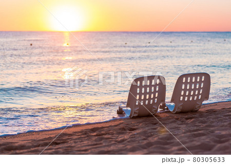Landscape of Two Lonely beachchairs near sea and beautiful sunrise 80305633