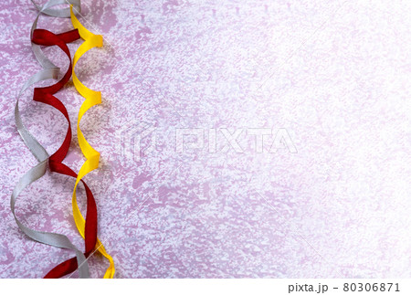 Ribbons on a pink background. Yellow and red ribbons on a light pink background. Background with ribbons. Ribbons on a pink background. Yellow and red ribbons on a light pink background. Background with ribbons. 80306871