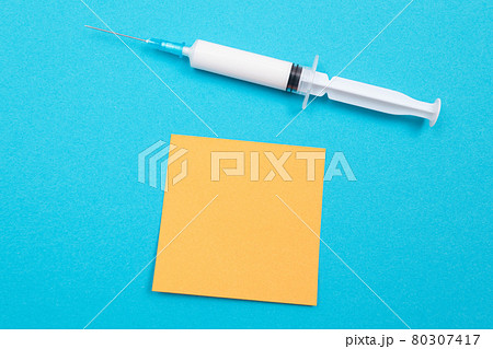 Vaccination or Revaccination Concept - A Medical Syringe on Blue Table Vaccination or Revaccination Concept - A Medical Syringe on Blue Table 80307417