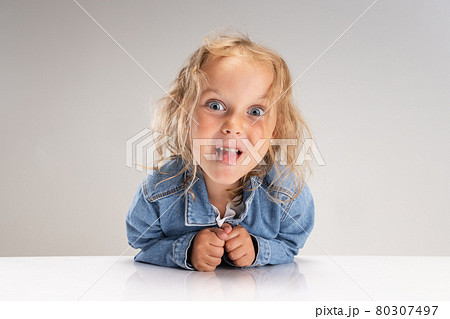 Close-up portrait of little preschool Caucasian girl in denim clothes looking at camera isolated on white studio background. Close-up portrait of little preschool Caucasian girl in denim clothes looking at camera isolated on white studio background. 80307497