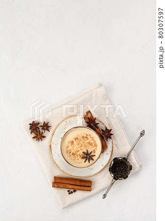 Indian Masala chai tea. Traditional Indian hot drink with milk and spices on white concrete background. Top view, flat lay. Copy space Indian Masala chai tea. Traditional Indian hot drink with milk and spices on white concrete background. Top view, flat lay. Copy space 80307597