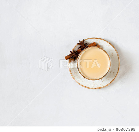Indian Masala chai tea. Traditional Indian hot drink with milk and spices on white concrete background. Indian Masala chai tea. Traditional Indian hot drink with milk and spices on white concrete background. 80307599