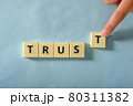 Man hand complete word Trust on plastic block 80311382