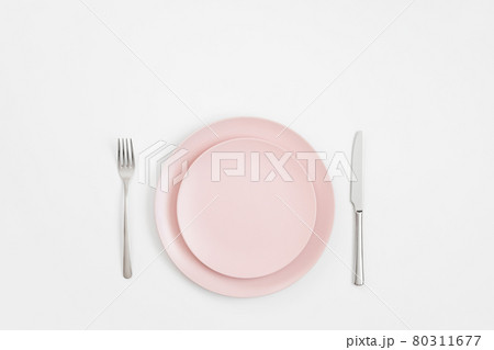 Empty pink plate and silver cutlery on a white background. Minimal table setting. Mockup or template. View from above. Copy space. Empty pink plate and silver cutlery on a white background. Minimal table setting. Mockup or template. View from above. Copy space. 80311677