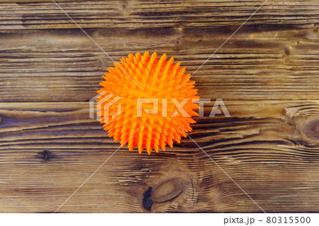Orange dog toy ball on wooden background. Top view 80315500
