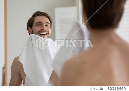 Happy attractive young millennial guy drying beard with white towel 80316460
