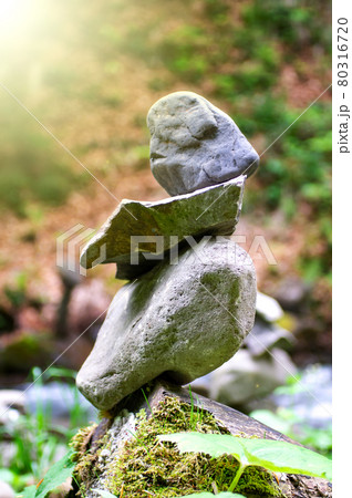 Rock pyramid, rock balancing art. Close-up of a stack of stones in perfect balance in a mountain forest. Sun rays. Meditation, balance, peace. Hobby. Vertical photo. Rock pyramid, rock balancing art. Close-up of a stack of stones in perfect balance in a mountain forest. Sun rays. Meditation, balance, peace. Hobby. Vertical photo. 80316720